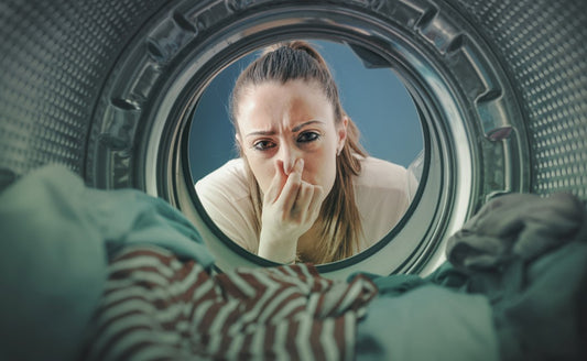 women closing nose near washerwomen smiling during laundry