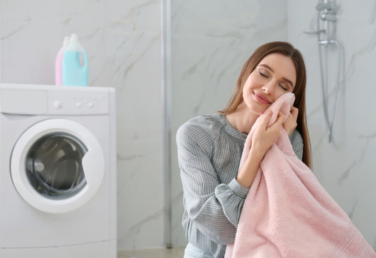 woman with fresh laundry near a washing machinewashing machine in a laundry room